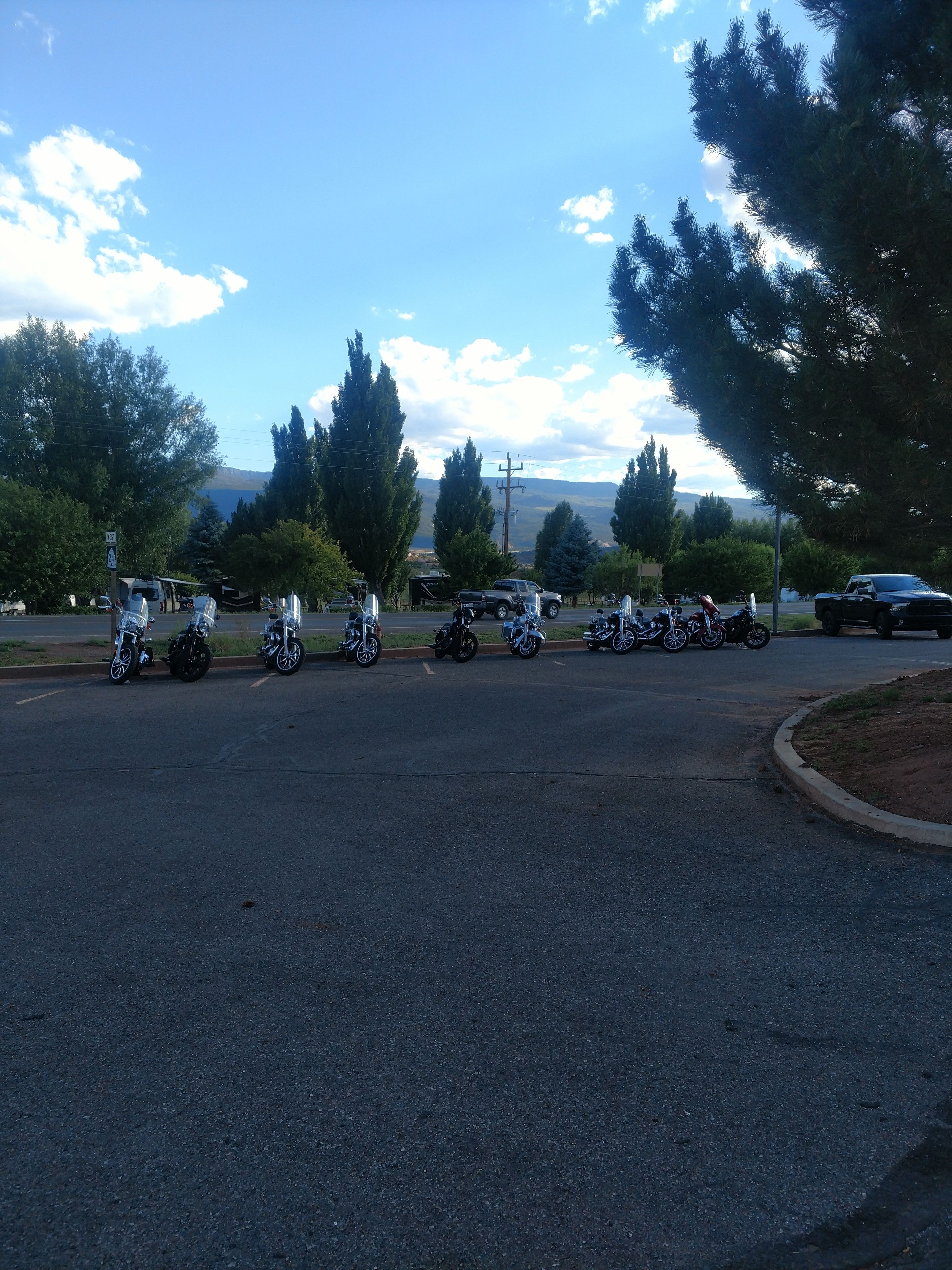A parking lot with several motorcycles and a truck.