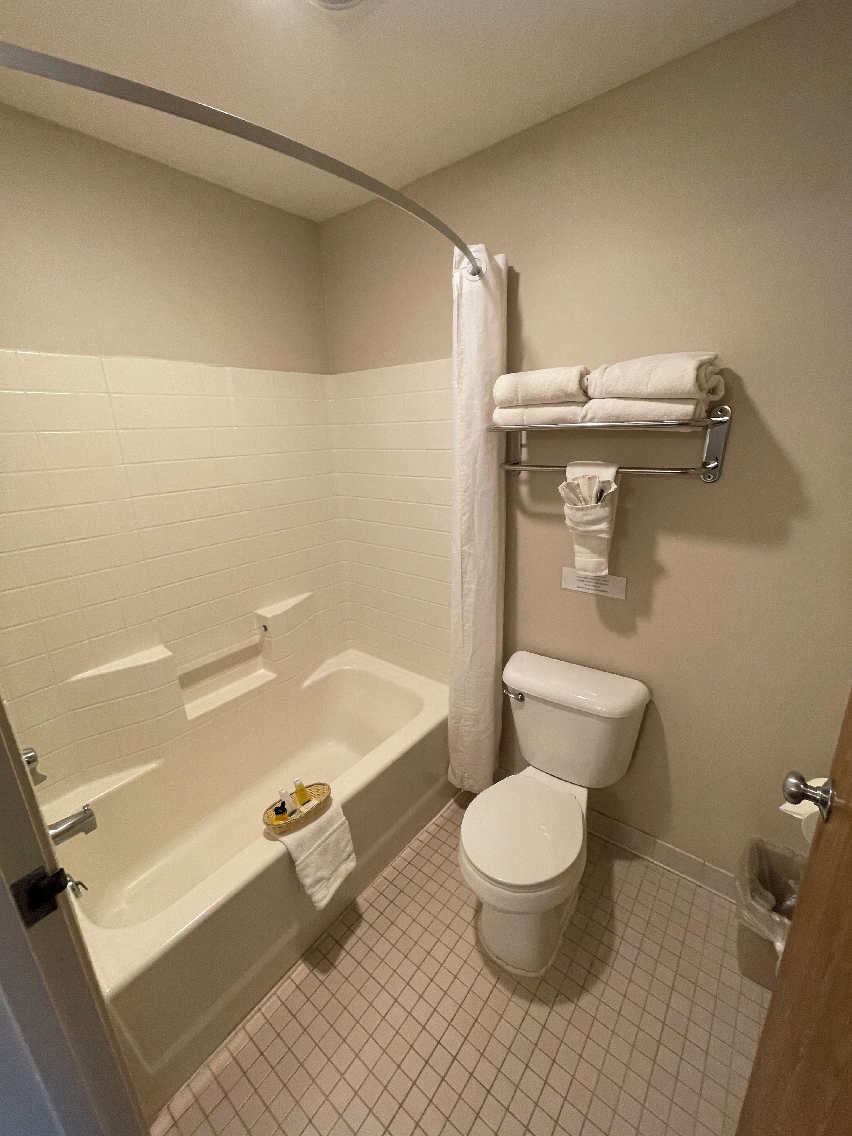 A bathroom with a bathtub, toilet, and towel rack.