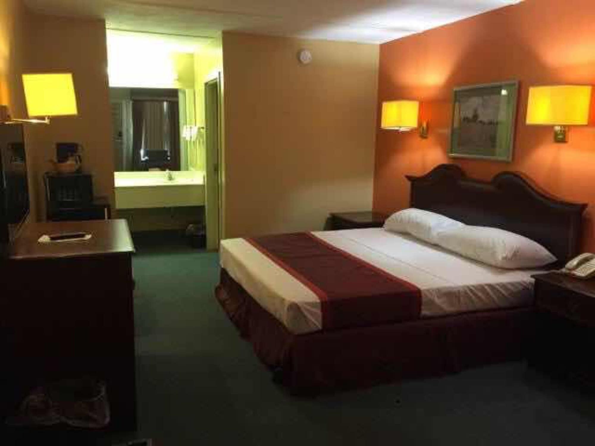 Une chambre d’hôtel équipée d’un lit, de lampes de chevet, d’un bureau et d’un téléphone.