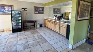 A small kitchenette with a refrigerator, a sink, and a tiled floor. - Motel 6 Bracey, VA – I-85 (Bracey)