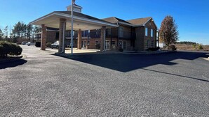 A two-story building with a covered parking area and a flagpole. - Motel 6 Bracey, VA – I-85 (Bracey)