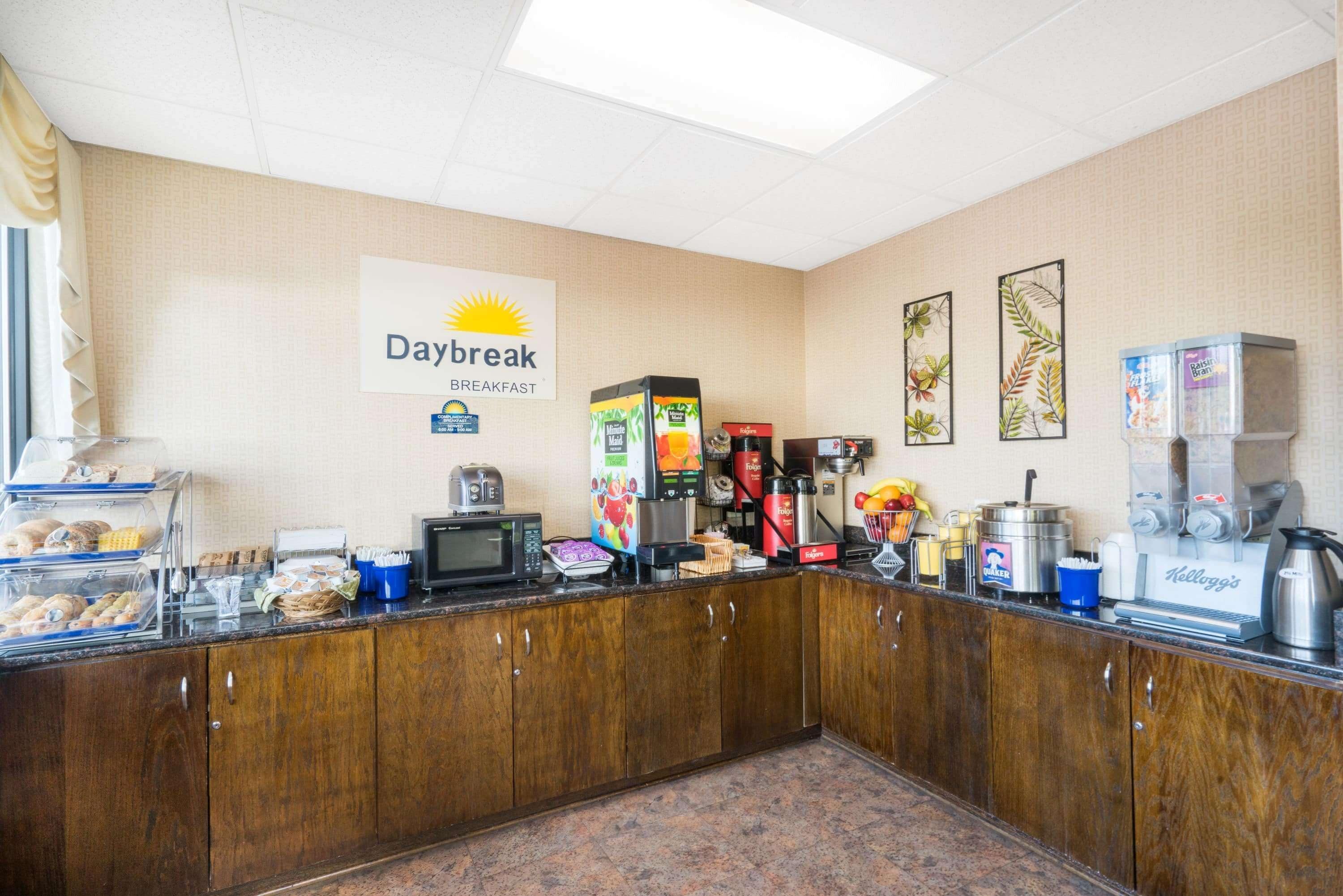 Ein Frühstücksbereich mit einem Schild mit der Aufschrift "Daybreak Breakfast", ausgestattet mit einer Kaffeemaschine, einem Toaster und verschiedenen Speisen.
