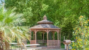 A gazebo with a roof and railings, surrounded by trees and a grassy area. - Days Inn by Wyndham Centerville (Centerville)