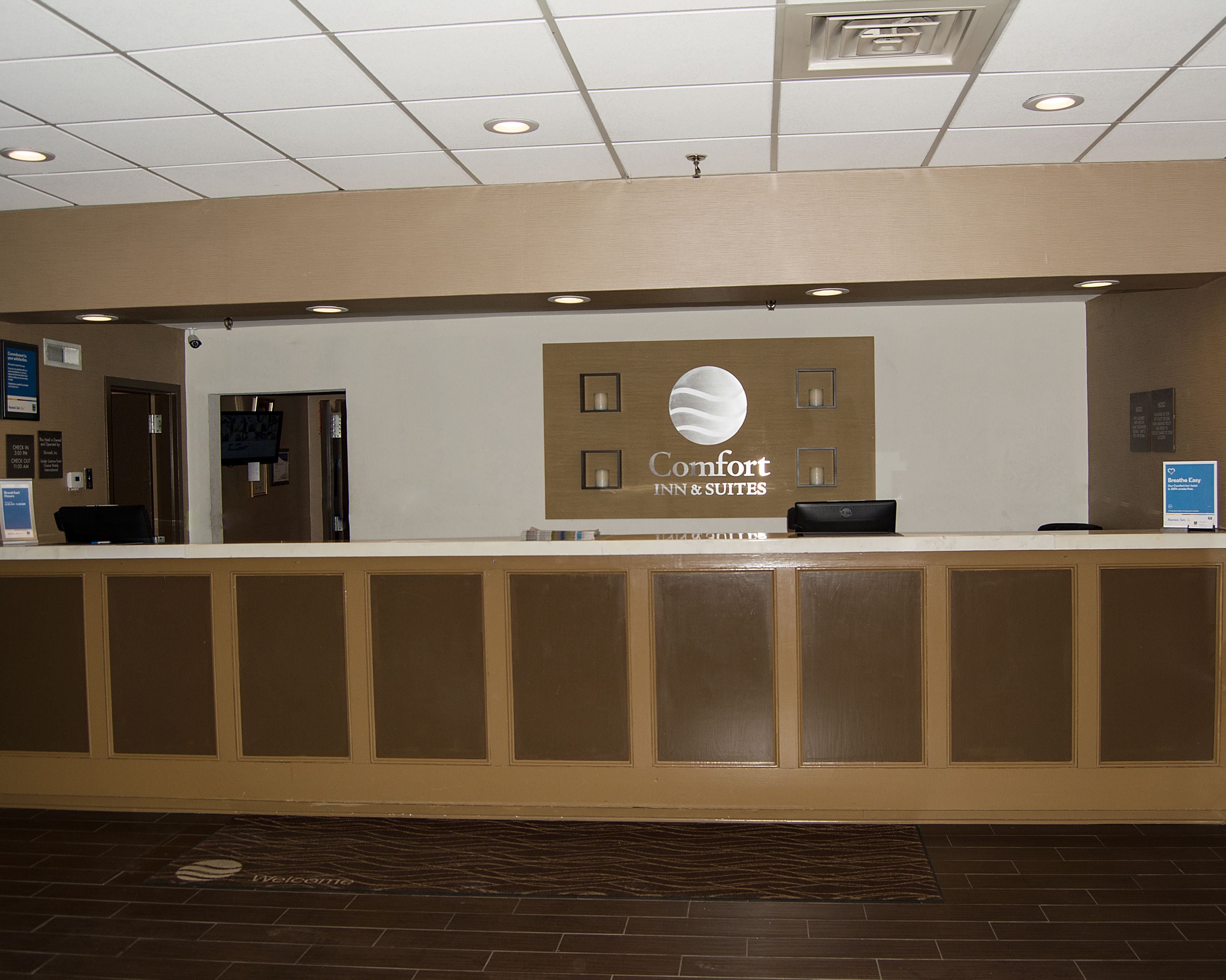 A reception desk with a sign for 'Comfort Inn & Suites'.