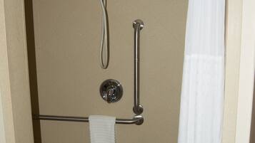 Une salle de bain équipée d’une douche, d’une barre d’appui et d’un porte-serviettes.