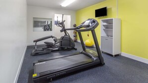 A gym with treadmills, an elliptical, and a stationary bike. - Days Inn by Wyndham Paxton (Paxton)