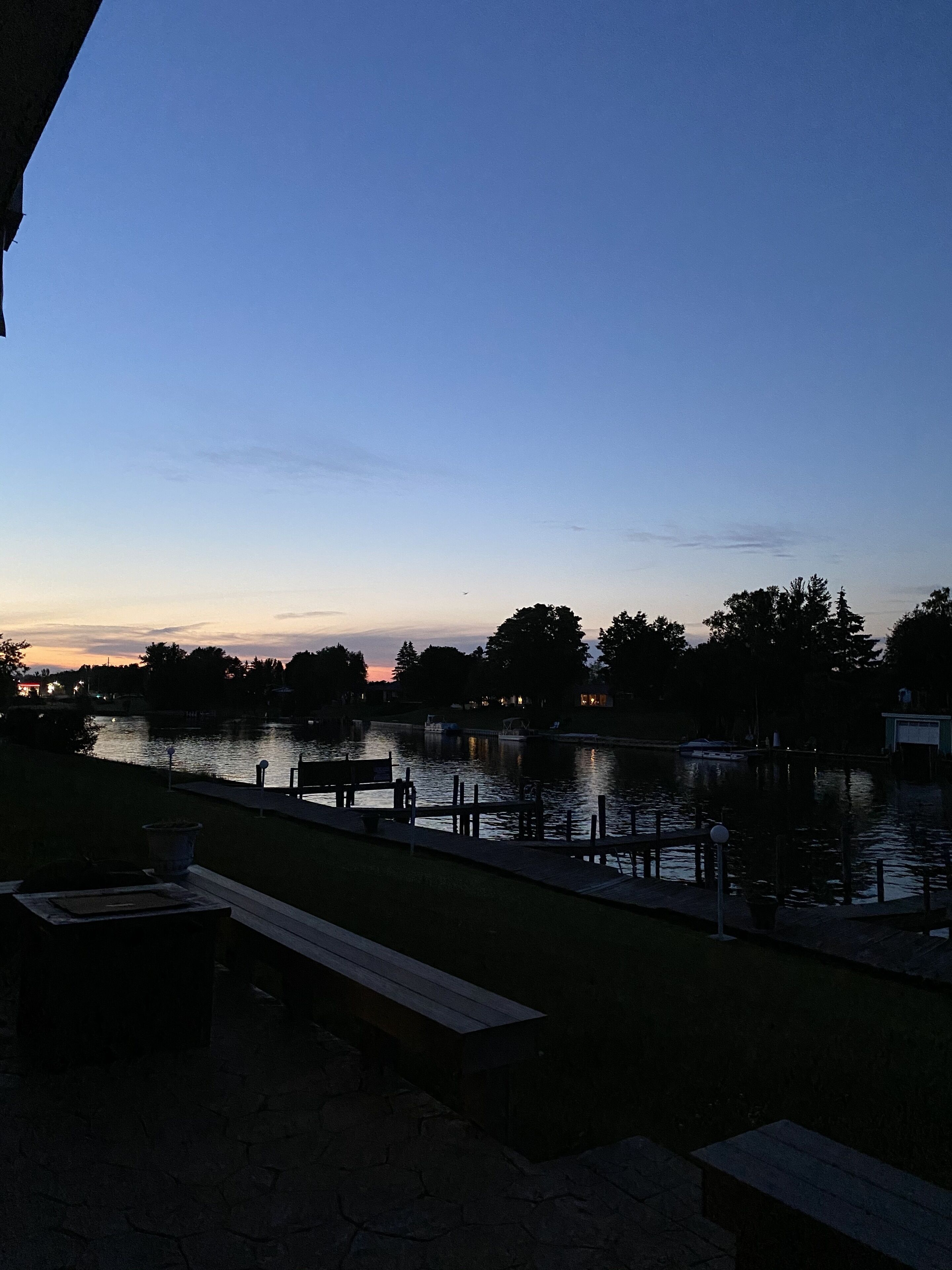 Une vue sur le lac avec un quai et des bancs.