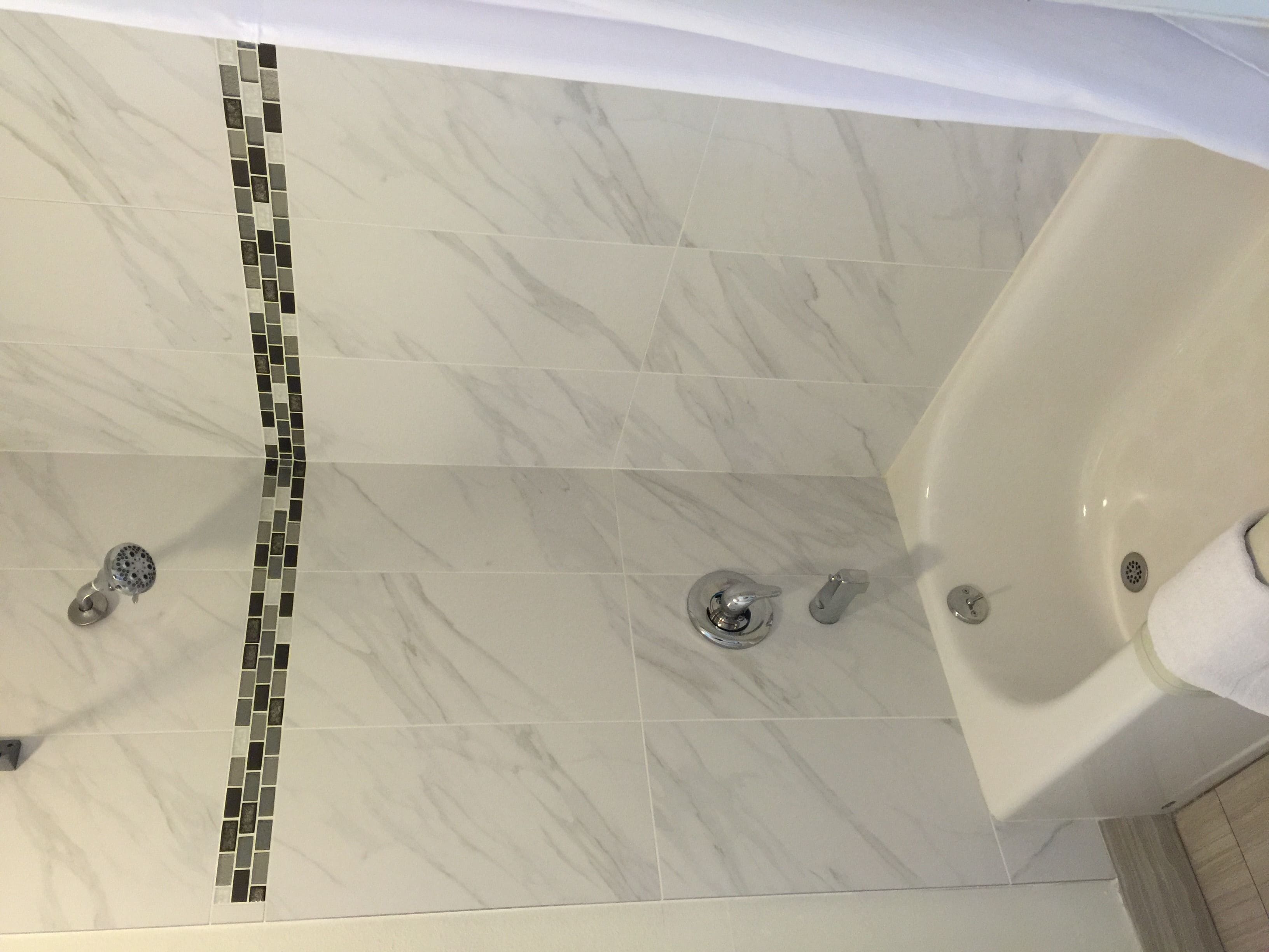 A bathroom with a large bathtub, a shower, and a sink.