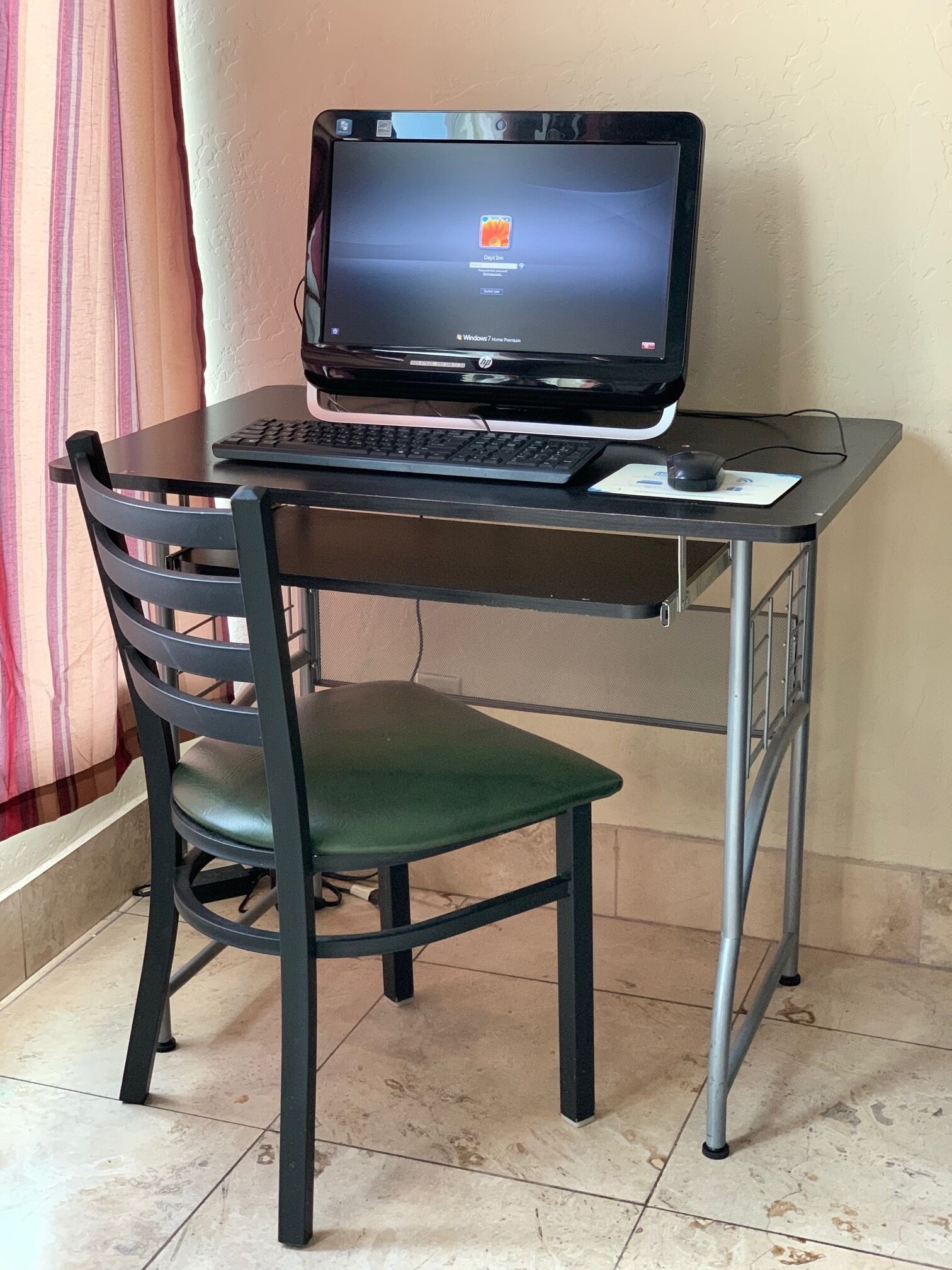 A computer desk with a monitor, keyboard, and mouse.