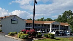 Un motel llamado Sylvania Inn, con un letrero, un estacionamiento y un edificio con área cubierta.