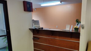 Una recepción con un cartel que indica los horarios de registro y una nota sobre la disponibilidad de internet.