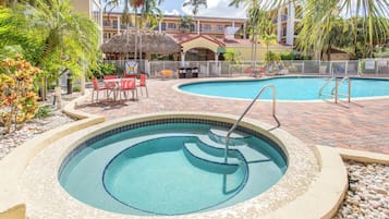 Una piscina al aire libre, sillones reclinables de piscina