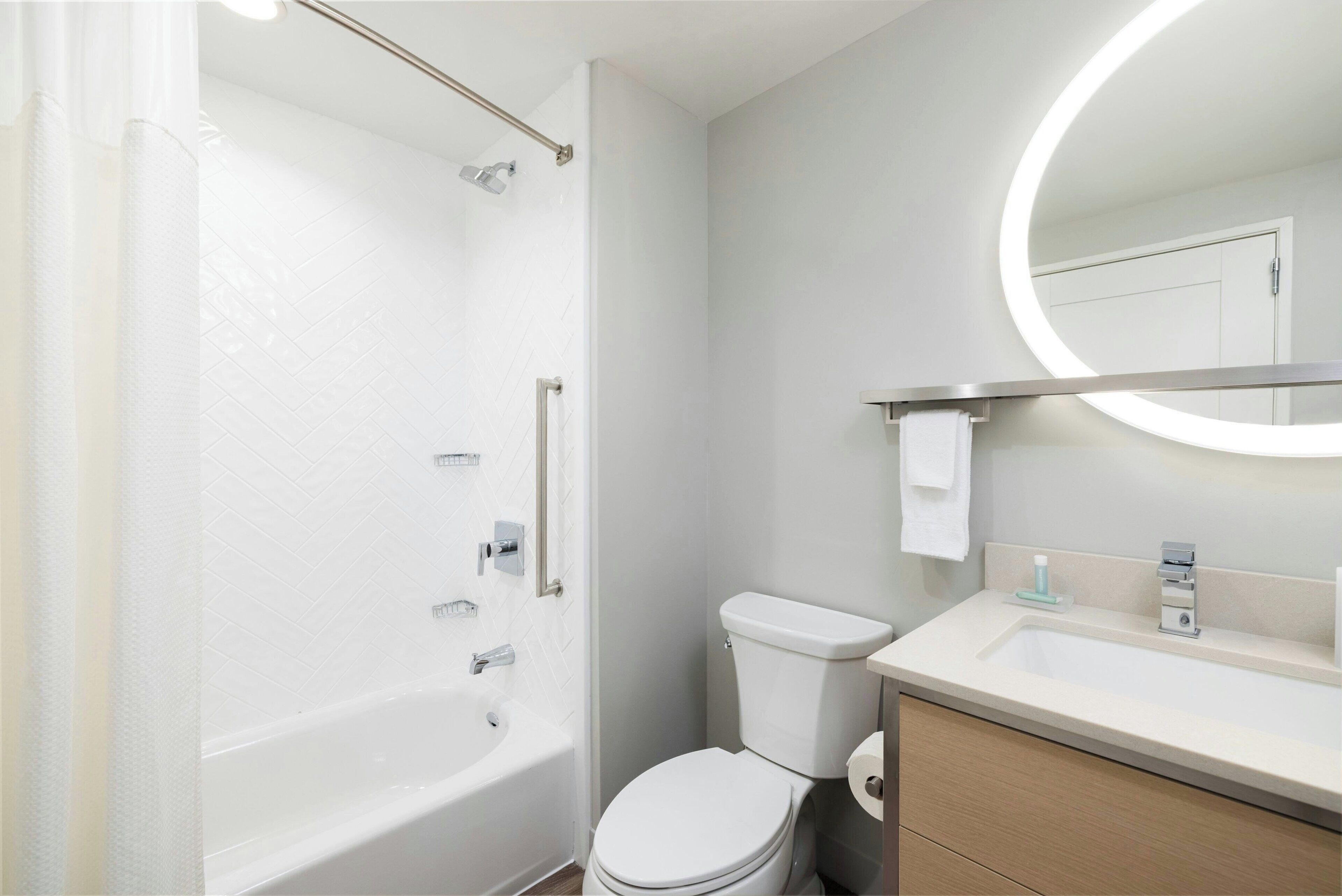 A modern bathroom with a bathtub, toilet, and sink.