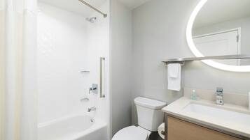 A modern bathroom with a bathtub, toilet, and sink.