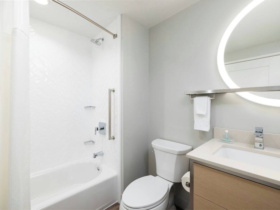 A modern bathroom with a bathtub, toilet, and sink.