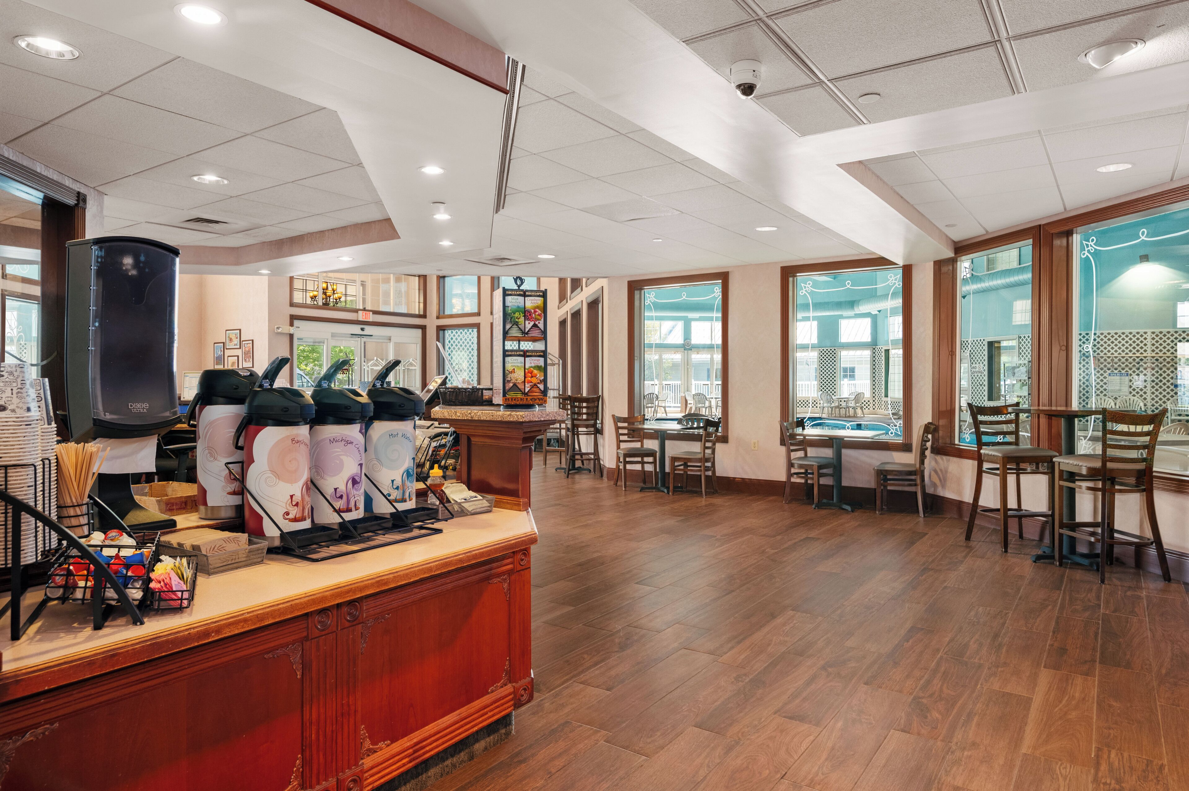 Un restaurant spacieux doté d’un plancher en bois, d’un comptoir de buffet et de grandes fenêtres.