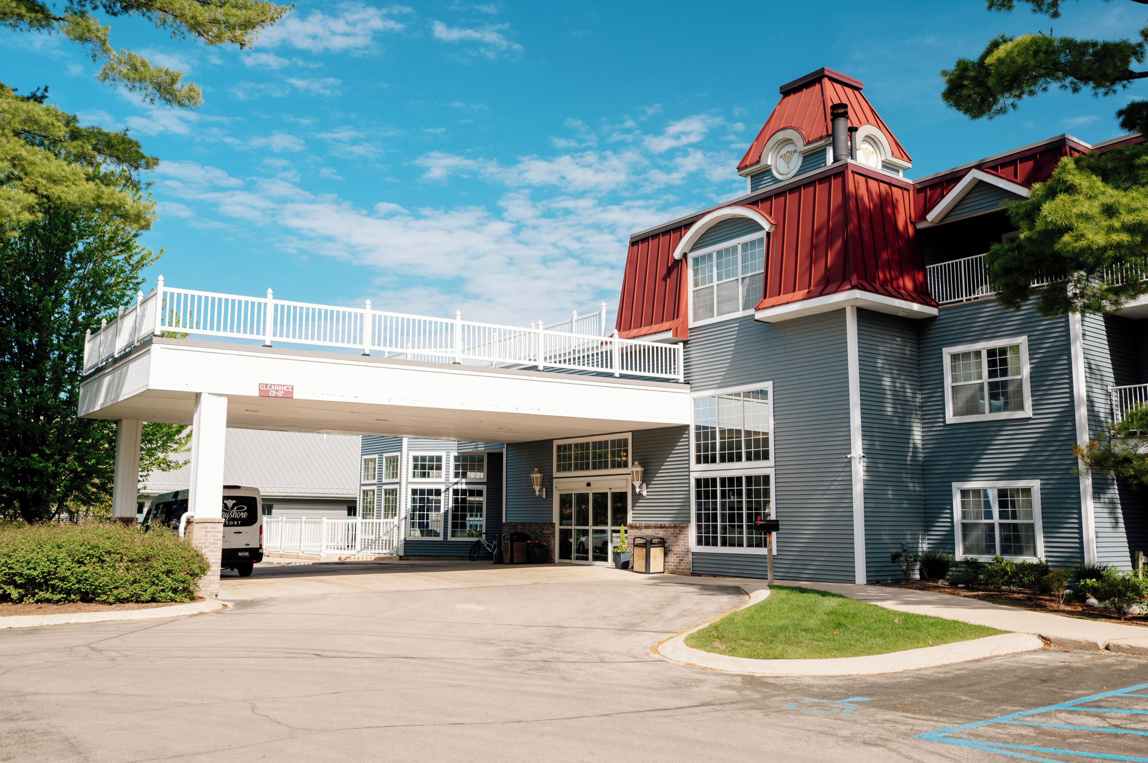 A two-story building with a red roof and a covered walkway.