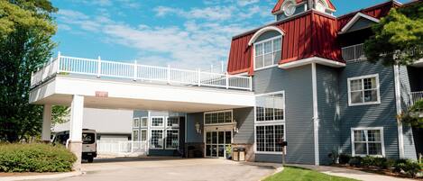 A two-story building with a red roof and a covered walkway.