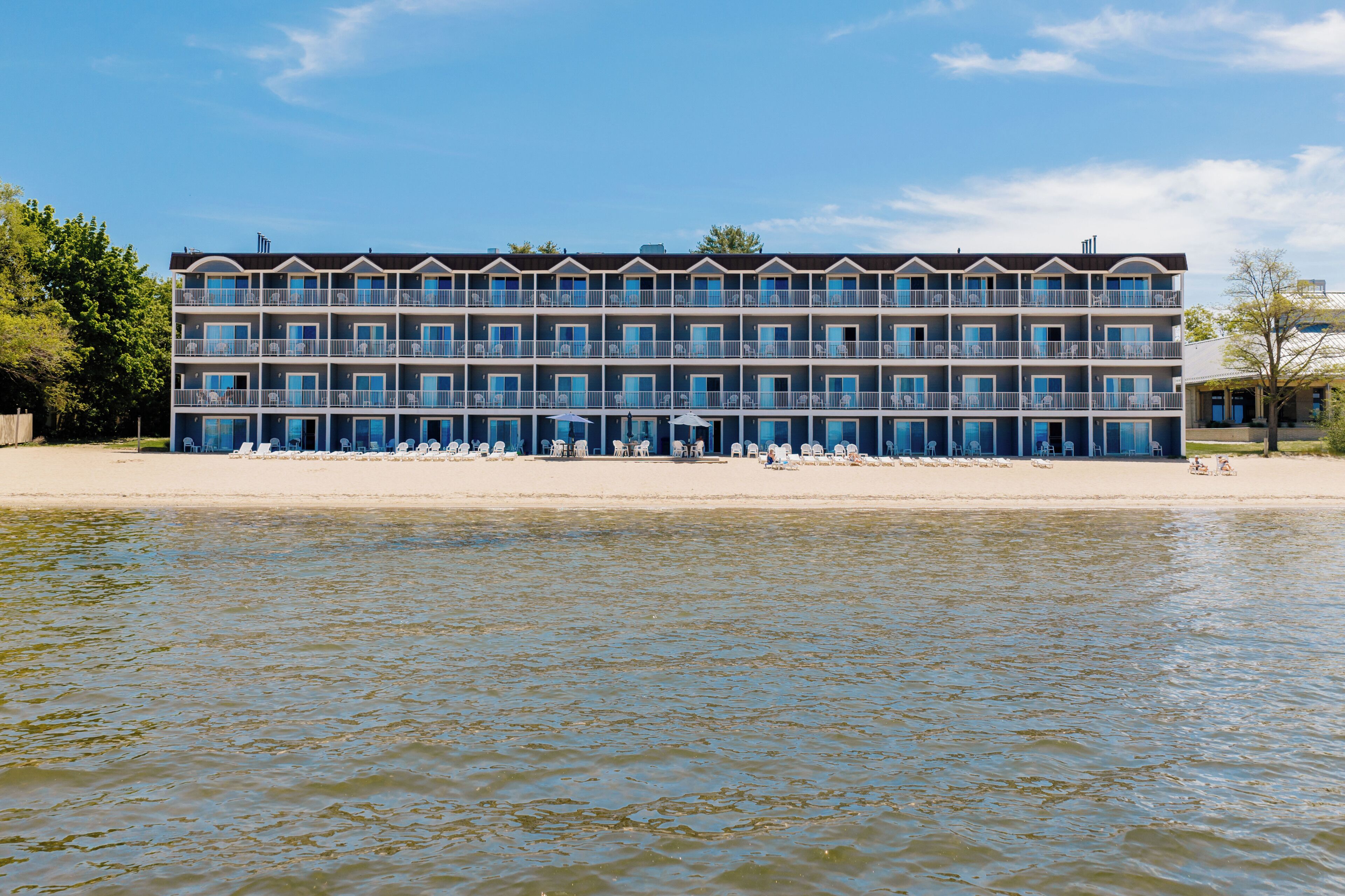 Un hotel de varios pisos con balcones, situado junto al agua.