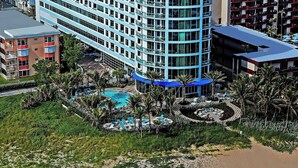 An aerial view of a beach with blue umbrellas and a hotel in the background. - Residence Inn Fort Lauderdale Pompano Beach / Oceanfront (Pompano Beach)