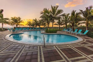 Una piscina al aire libre, sillones reclinables de piscina
