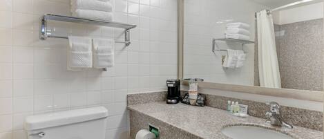 Un baño con inodoro, lavamanos y perchero para toallas.