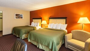 A hotel room with two beds, a chair, and a lamp. - Quality Inn & Suites Lincoln South (Lincoln)