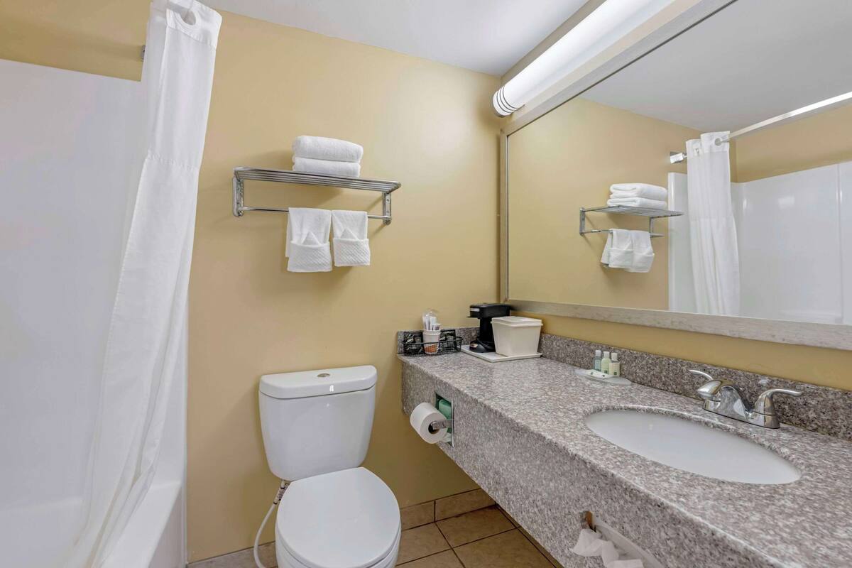 A bathroom with a toilet, sink, and towel rack.