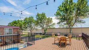 A wooden deck with a pool, outdoor seating, and string lights. - Quality Inn & Suites Lincoln South (Lincoln)