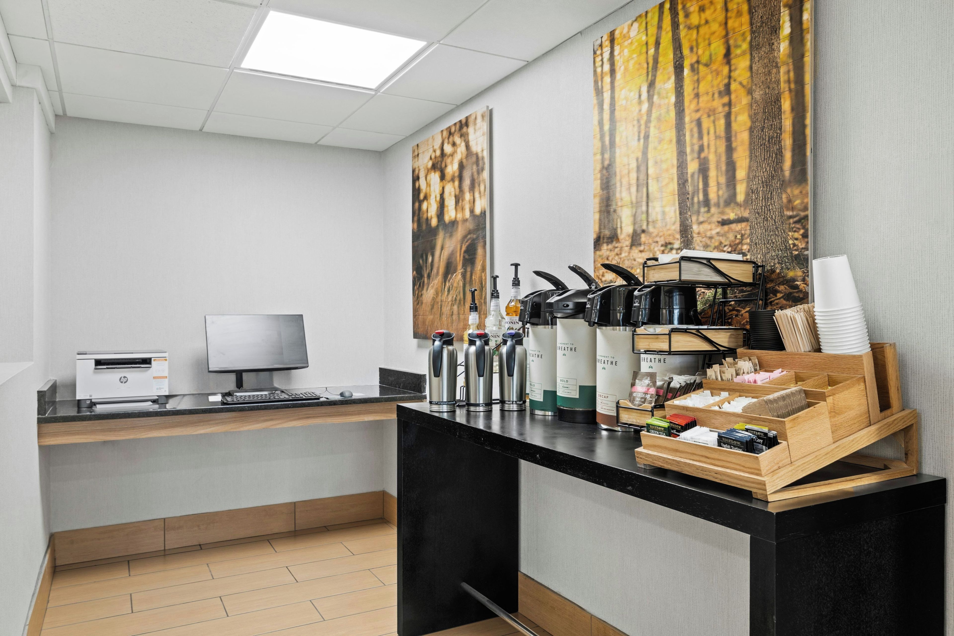 Uma cozinha moderna com um computador desktop, máquinas de café e um expositor de grãos de café.