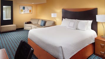 Una habitación de hotel con una cama grande, un sofá, un escritorio y una silla.