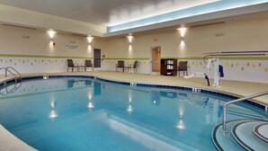 Una piscina interior con una silla de salvavidas, un vestuario y una recepción.