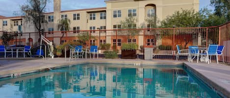 Una piscina al aire libre, sillones reclinables de piscina