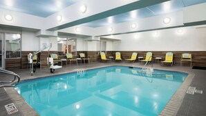 A swimming pool with clear blue water, yellow lounge chairs, and a tiled deck. - Fairfield Inn & Suites San Antonio Airport/North Star Mall (San Antonio)