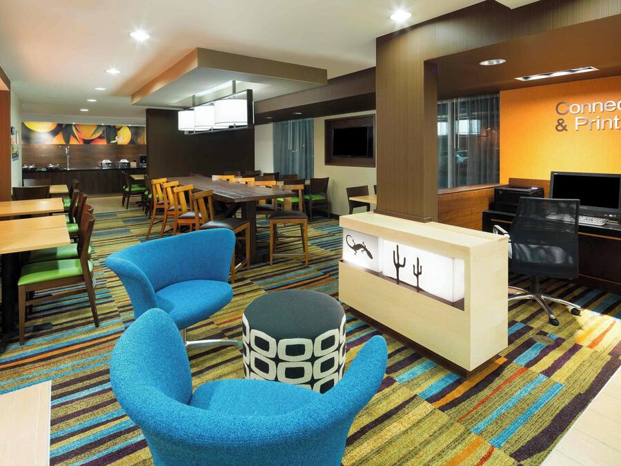 A hotel lobby with a reception desk, seating area, and a 'Connect & Print' station.