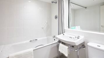 Un baño moderno con bañera, lavamanos e inodoro.