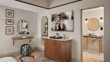 A modern bathroom with a wooden vanity, a large mirror, and a wall-mounted TV.