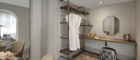 Hotelkamer met zithoek, een kaptafel met spiegel, een kledingrek en een klein tafeltje met toiletartikelen.