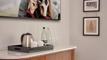 A modern bathroom with a wooden vanity, a mirror, and a framed photograph above the mirror.