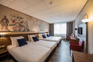 A hotel room with two beds, a desk, a chair, a TV, and a large wall map. - Tulip Inn Leiden Centre (Leiden)