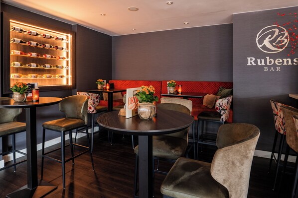 A bar area with round tables and chairs, a wall-mounted wine rack, and a sign reading "Rubens BAR". - Tulip Inn Leiden Centre (Leiden)