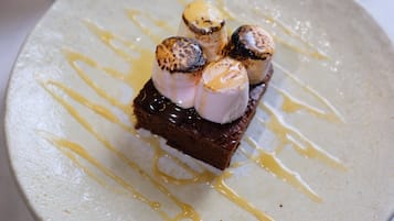 A dessert with marshmallows and chocolate sauce on a plate.