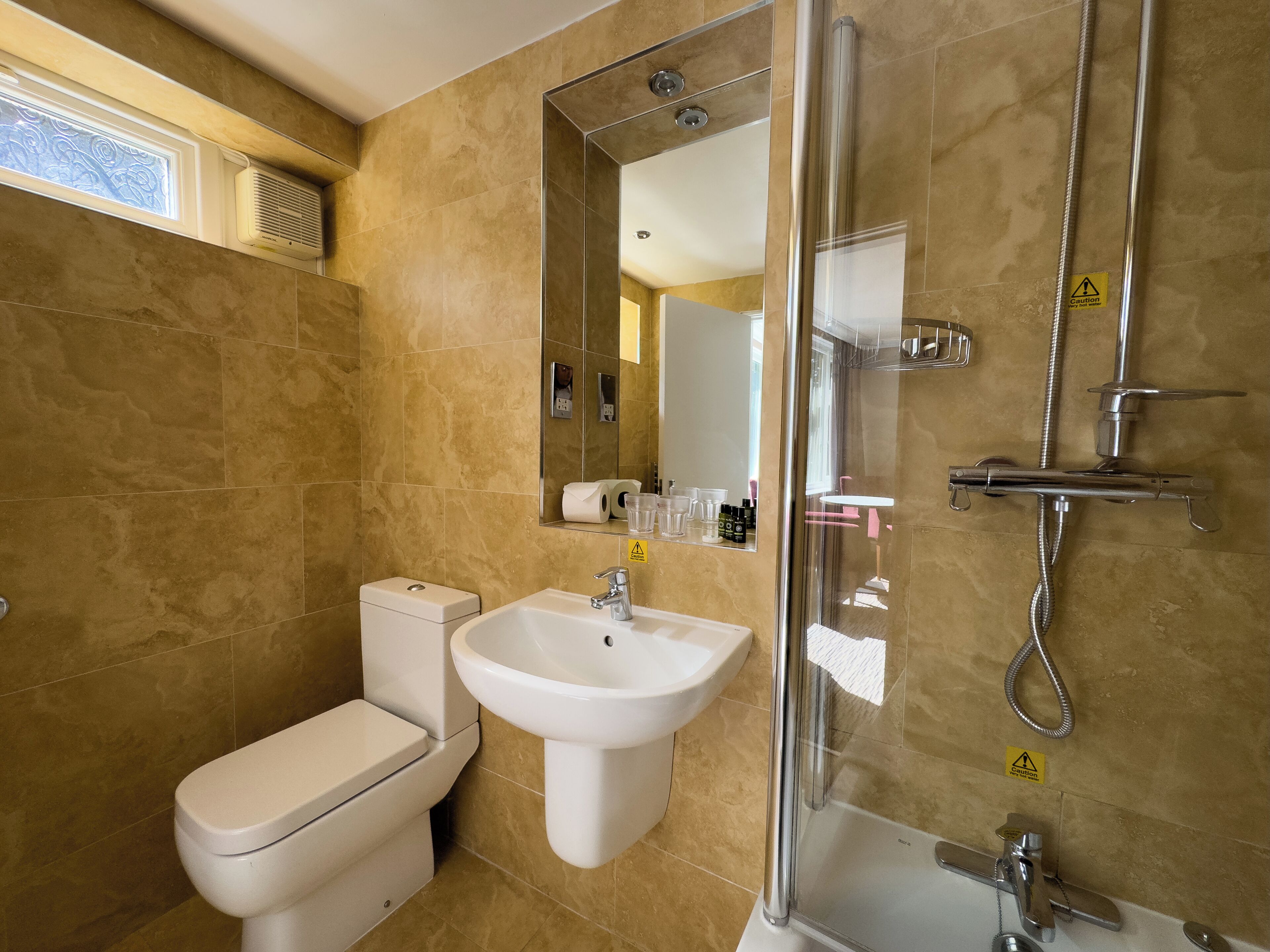 A modern bathroom with a toilet, sink, and glass-enclosed shower.