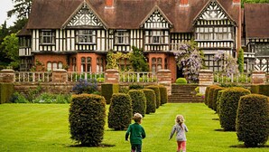 A Tudor-style building with symmetrical architecture, a well-manicured lawn, and a formal garden with neatly trimmed hedges. - The Mount Country Manor Hotel & Golf (Wolverhampton)