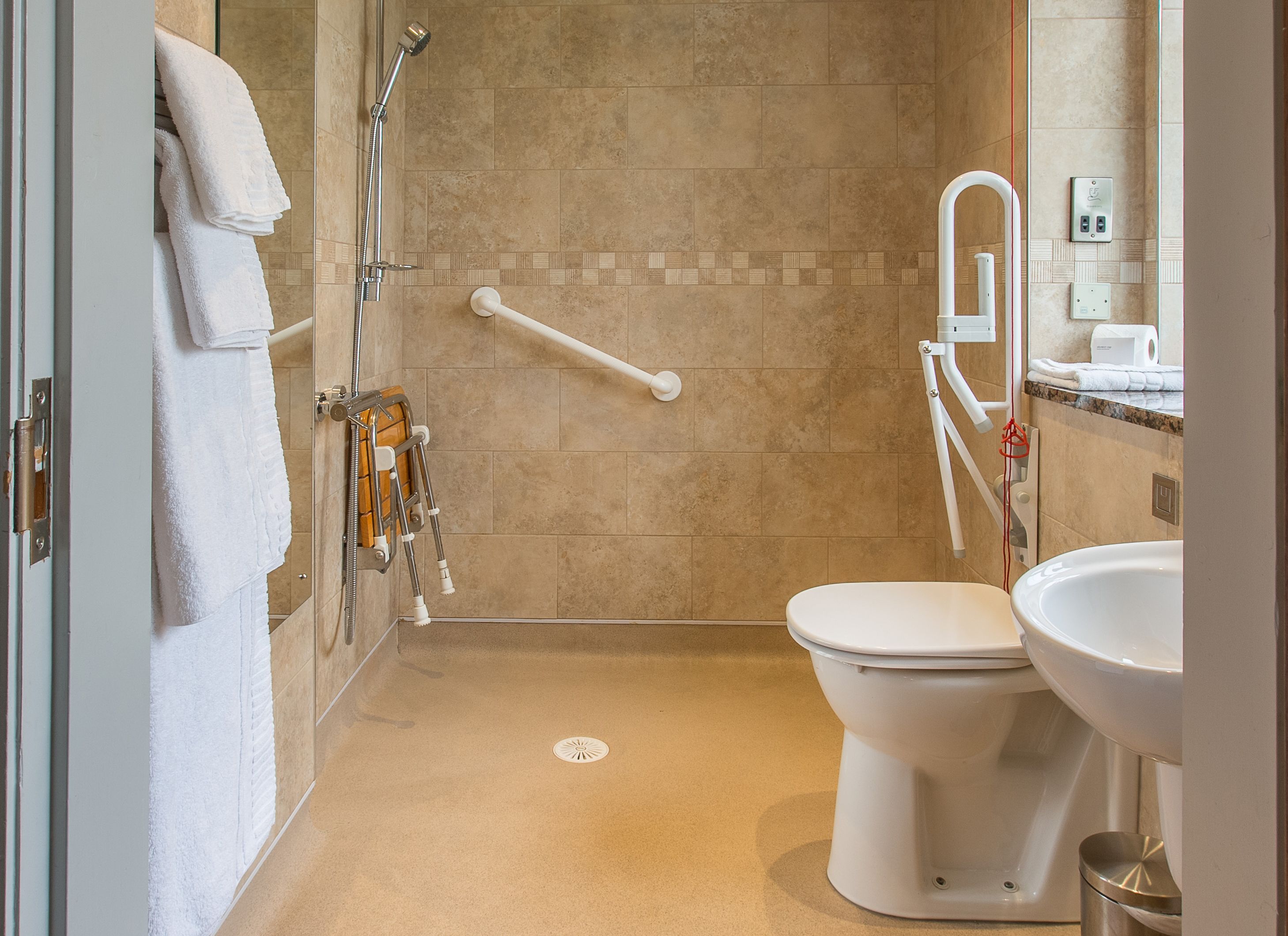 A modern bathroom with a shower, toilet, and sink.