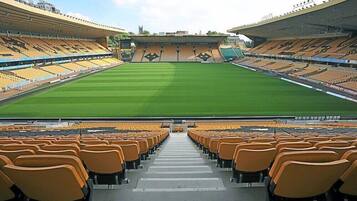 A stadium with tiered seating and a central field.