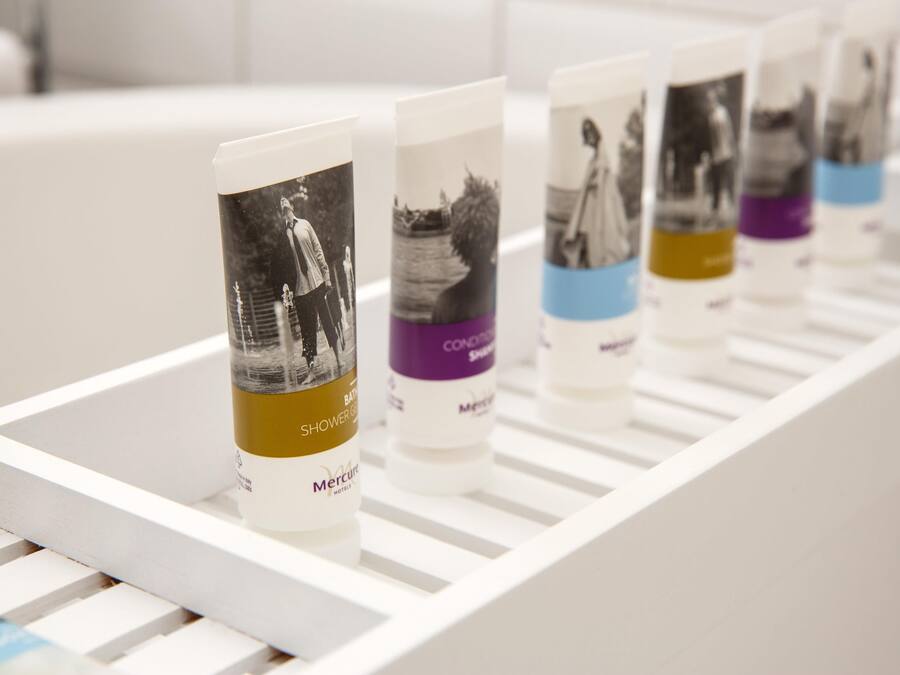 A row of toiletries on a white shelf.