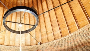 Un área de recepción con techo de madera, pared de ladrillo y mostrador de recepción.