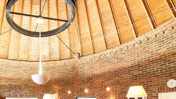 Experience the unique blend of contemporary and traditional styles in our lobby, featuring a high ceiling, hexagonal tile floor, and exposed brick walls.