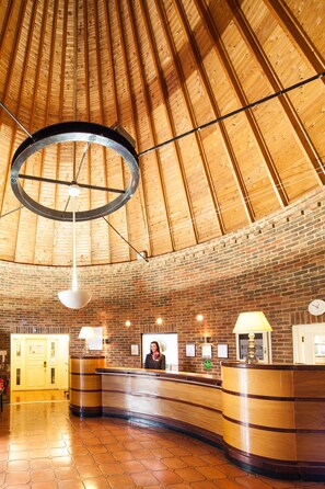 Experience the unique blend of contemporary and traditional styles in our lobby, featuring a high ceiling, hexagonal tile floor, and exposed brick walls.